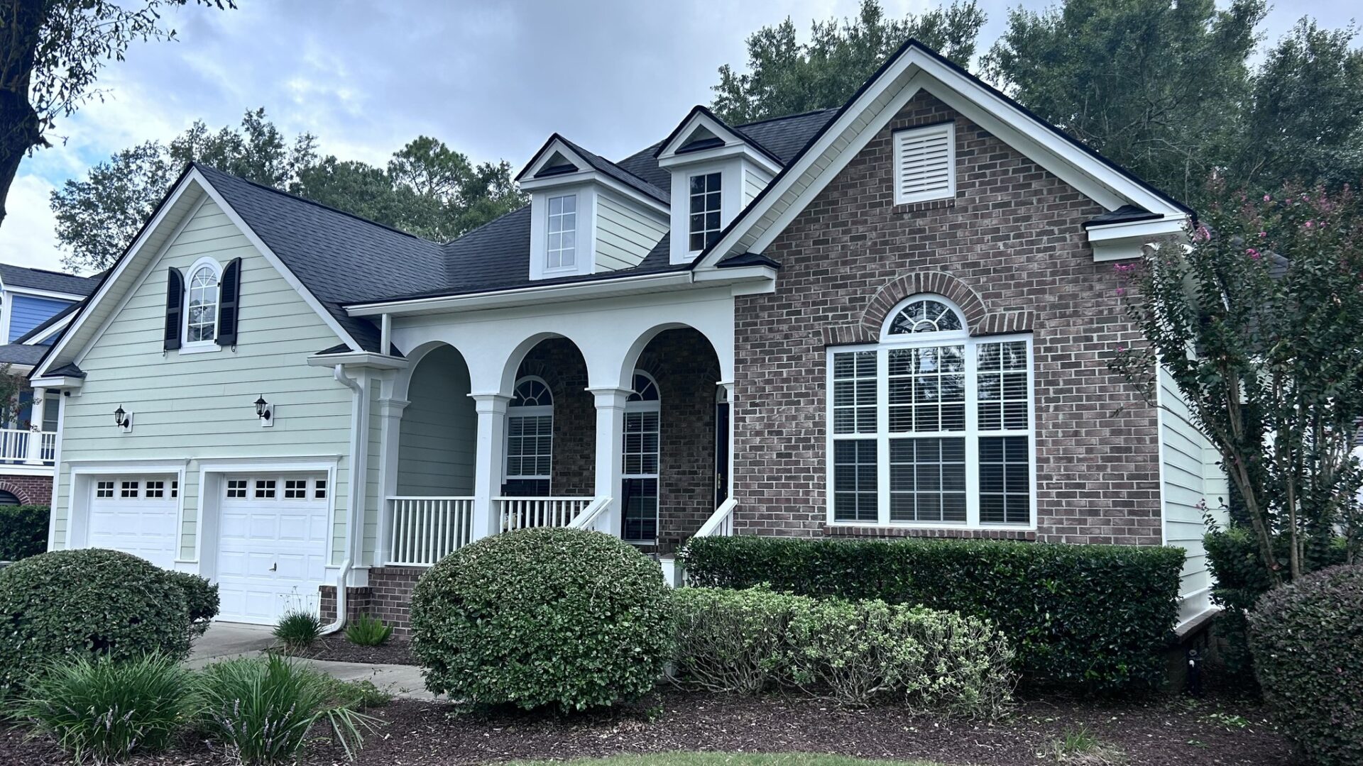 A house with a lot of windows and bushes