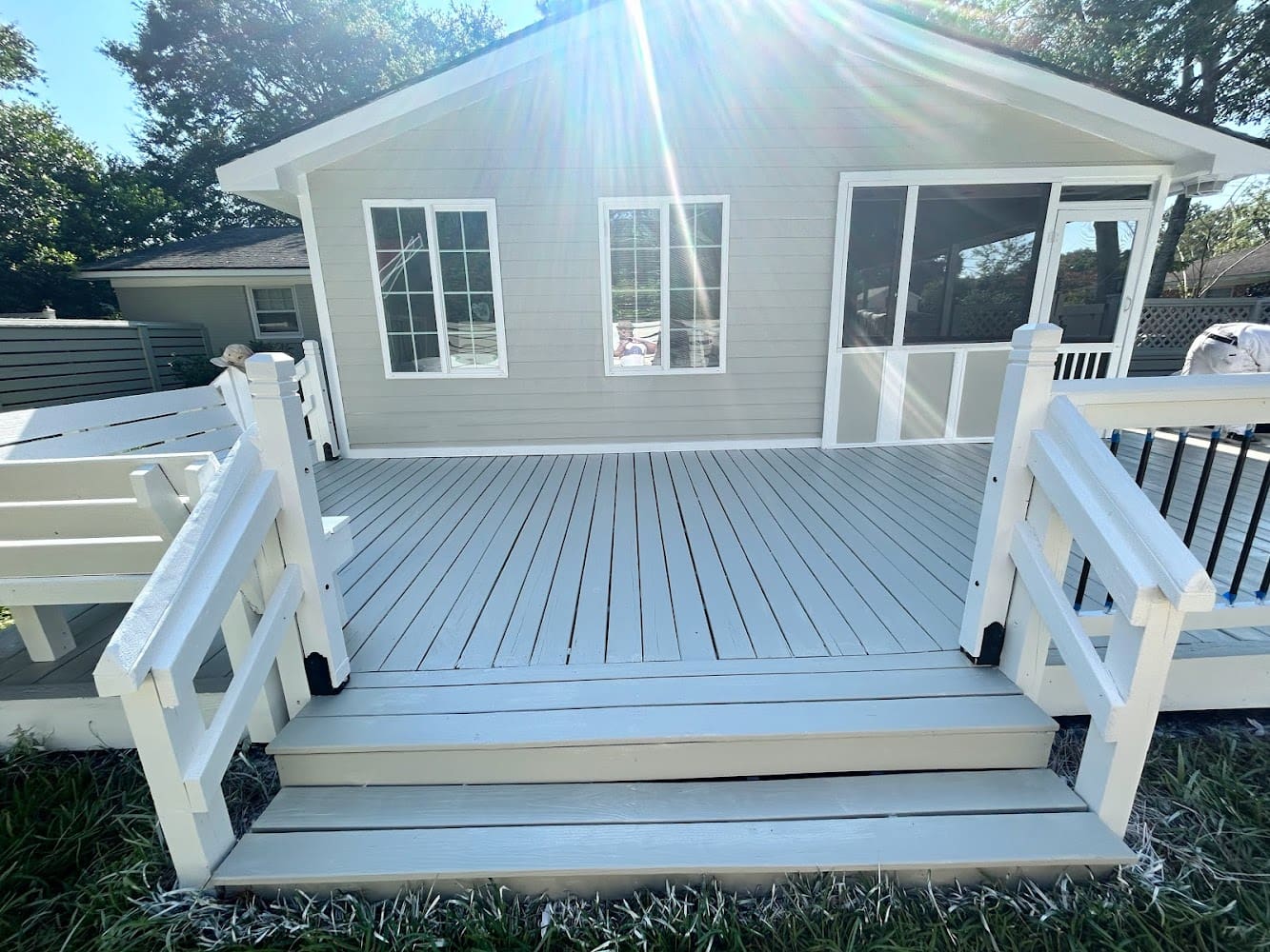 A white deck with steps leading to the back of it.