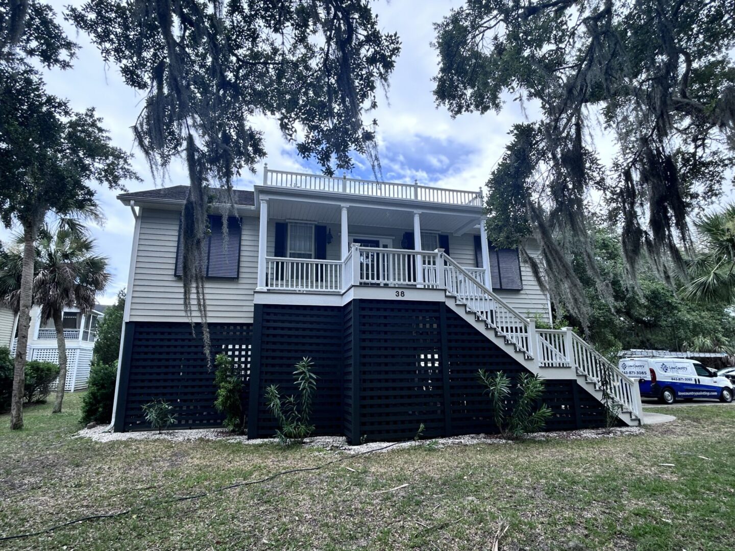 A large white house with black trim and steps.