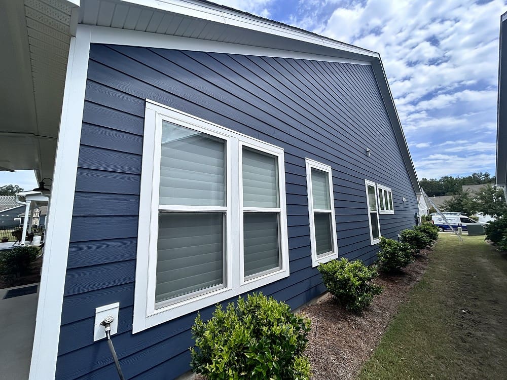 A blue house with white trim and windows.