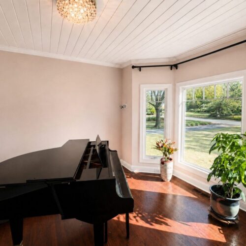 Inteior-Painting-Charleston-sc A bright, polished interior featuring freshly painted warm neutral walls, clean white trim and ceiling details, rich hardwood floors, and a grand piano. The smooth wall finish and crisp architectural details showcase the quality of a professional residential interior painting project.